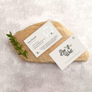 White paper business card, mockup with natural stone and boxwood branch on gray concrete background. Blank, flat lay, top view, still life, canvas, copy space.